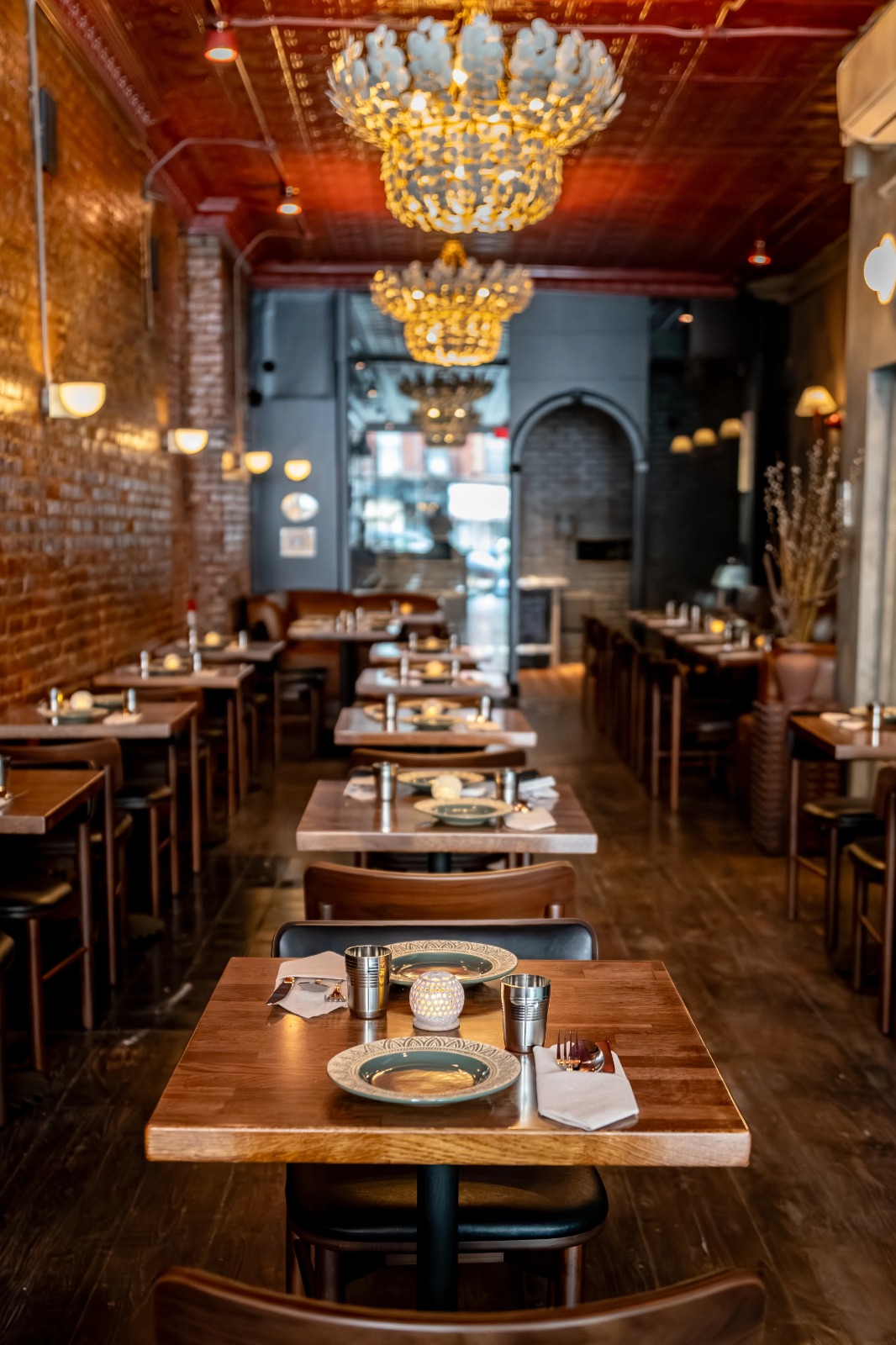 Dravida dining room with coconut shell chandeliers and warm brick interior