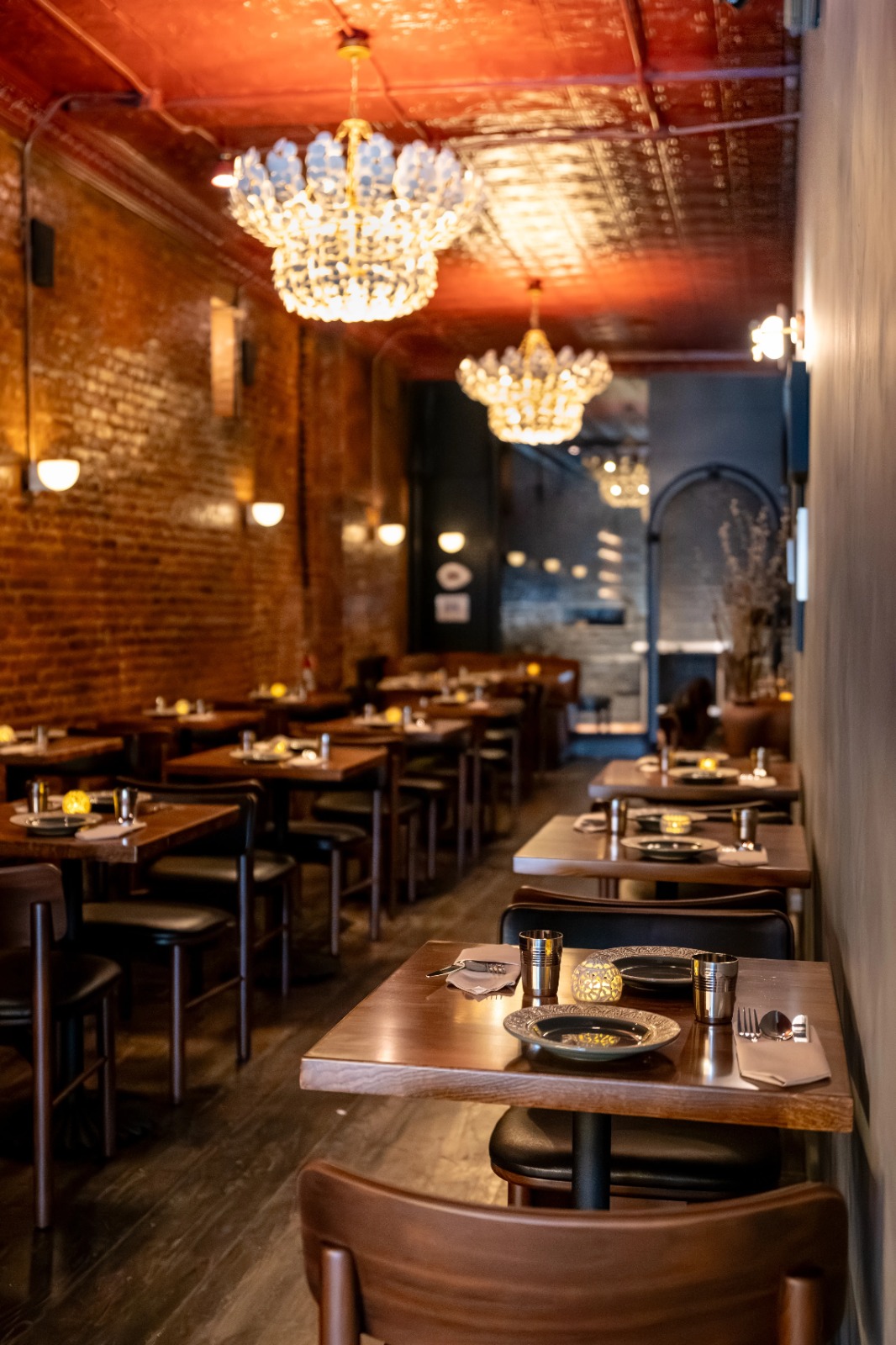 Dravida dining room with chandeliers and brick walls